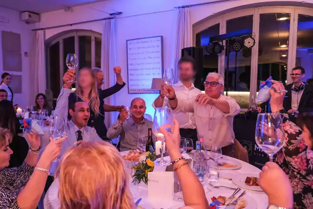 Invitati che brindano a tavola durante la festa di un battesimo